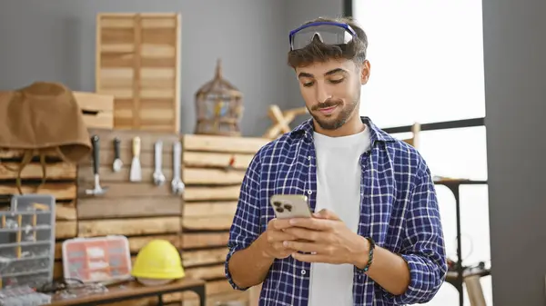 Smiling Young Arab Man Professional Carpenter Cheerfully Texts His Smartphone — Stock Photo, Image