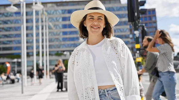 Stockholm sokaklarında kendinden emin gülümseyen genç, güzel İspanyol kadın.