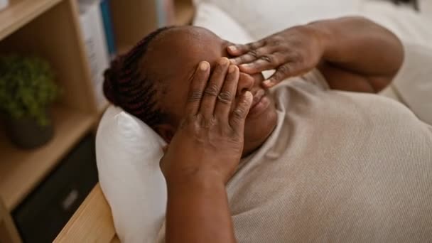 Zmęczona Afroamerykanka Komfortowo Zagnieżdżona Spokojnej Sypialni Pocierająca Oczy Leżąc Łóżku — Wideo stockowe