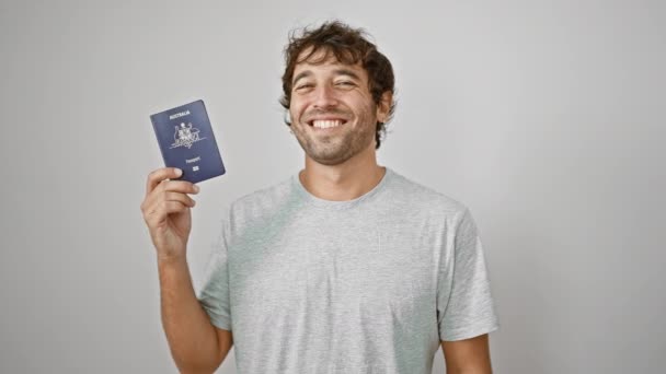 自信を持って幸せな若者は喜んでオーストラリアのパスポートを保持し 孤立した白い背景に微笑み 次の休日の冒険の準備ができています — ストック動画