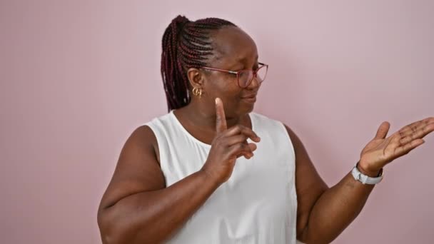 Радостная Африканская Американка Уверенно Стоящая Счастливо Указывающая Представляющая Изолированном Розовом — стоковое видео