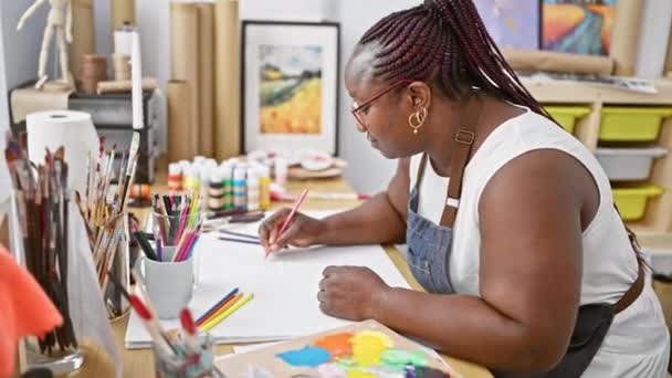 アフリカ系アメリカ人女性を中心に 芸術家を魅了し 屋内アートスタジオでノートに集中させた — ストック動画