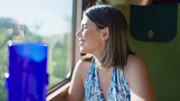 一个坐在城市地铁里的美丽的女人 在她旅行的过程中 从地铁车厢的窗户向外张望时 脸上洋溢着恐慌的美丽笑容 — 图库视频影像