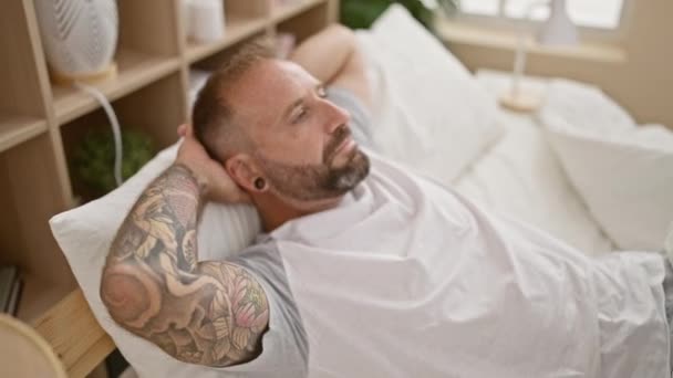 Yakışıklı Genç Bir Adam Rahat Bir Yatakta Uzanıyor Yatak Odasında — Stok video