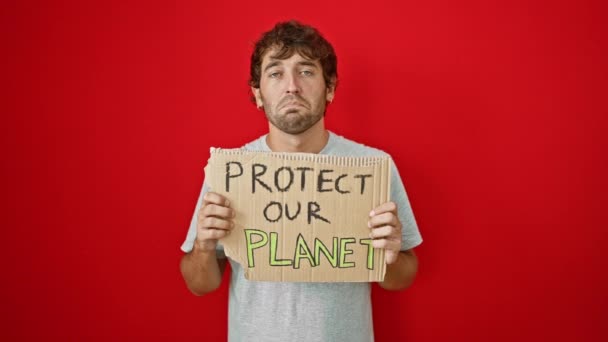 Depresyondaki Genç Adam Kırmızı Arka Planda Izole Edilmiş Bir Gezegenimizi — Stok video