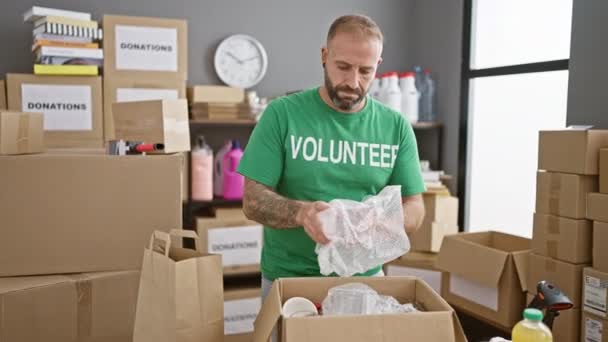 Aantrekkelijke Jongeman Die Hartstochtelijk Vrijwilligerswerk Doet Een Liefdadigheidscentrum Kartonnen Dozen — Stockvideo