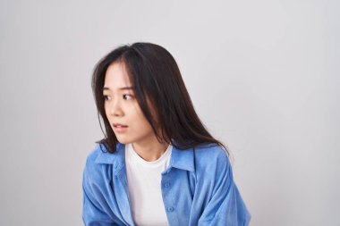 Beyaz arka planda duran genç Çinli kadın midesi üstünde duruyor çünkü hazımsızlık, acı verici bir hastalık kendini iyi hissetmiyor. Ağrı kavramı. 