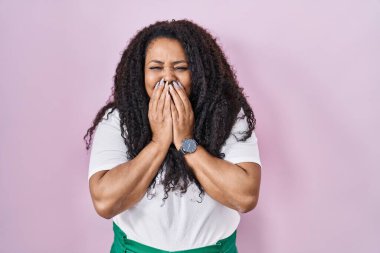 Artı, pembe arka planda dikilen İspanyol kadın gülüyor ve utanıyor kıkırdıyor ağzı ellerle, dedikoduyla ve skandal konseptiyle örtüyor. 