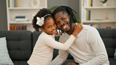 Afro-Amerikan baba ve kızı gülümsüyor. Kendilerine güveniyorlar.