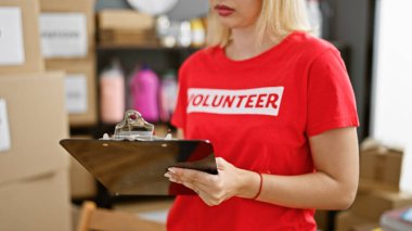 Genç sarışın kadın yardım merkezinde listeye gönüllü olarak yazıyor.