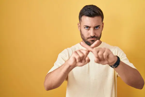 Handsome Hispanic Man Standing Yellow Background Rejection Expression Crossing Fingers — Stock Photo, Image