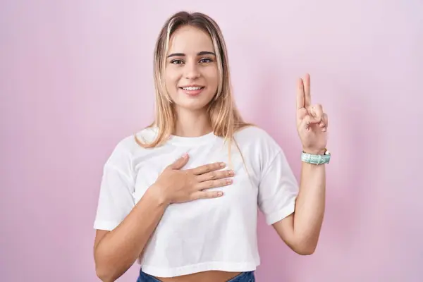 Young Blonde Woman Standing Pink Background Smiling Swearing Hand Chest — Stockfoto