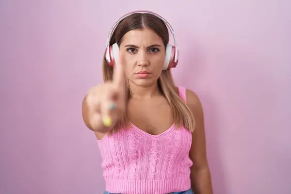 Young Blonde Woman Listening Music Using Headphones Pointing Finger Angry — Stock Photo, Image