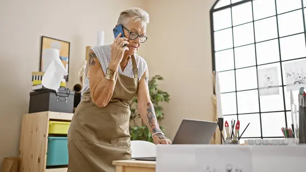 Zelfverzekerde Grijsharige Seniorenkunstenares Die Vakkundig Multitaken Uitvoert Smartphone Spreekt Terwijl — Stockfoto