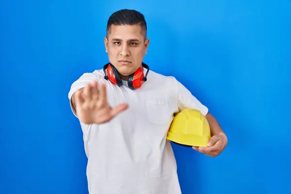 Hispanic Young Man Holding Hardhat Open Hand Doing Stop Sign — Stock Photo, Image