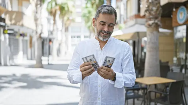 Young Hispanic Grey Haired Man Smiling Confident Counting Dollars Street — Stock Photo, Image