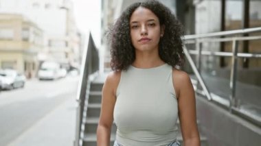 Sokakta kollarını kavuşturmuş genç, güzel İspanyol bir kadın.