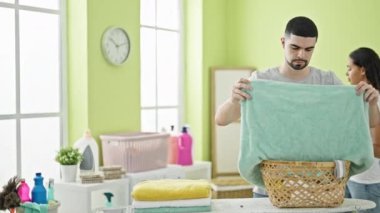 Güzel bir çift evde çamaşır yıkıyor, akıllı telefondan mesaj atıyor, çamaşırhanede kahve içiyor.