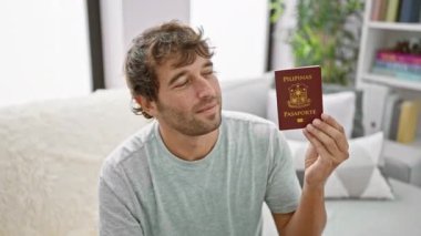 Kendine güveni tam bir genç adam, evdeki kanepesinde rahatça takılıyor, gururla Filipinli pasaportunu tutuyor, bir sonraki büyük macerasını bekliyor.