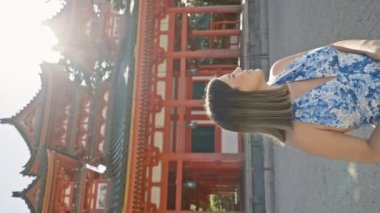 Güzel İspanyol kadın ayakta duruyor, eğleniyor ve gülümsüyor geleneksel jingu jingu türbesine bakarken, kyoto, japan