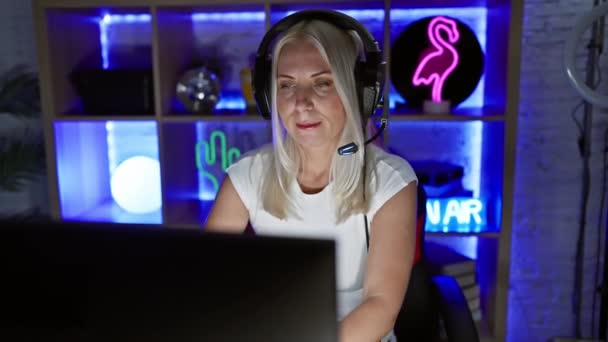 若い金髪の女性は ゲームの問題を解決することに懐疑的で コンピュータ画面に神経質に飛び込んでいます ゲーム室のネガティブなバイブ — ストック動画