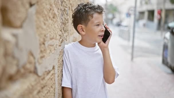 Bedårande Blond Pojke Tryggt Leende Hålla Smartphone Och Engagera Sig — Stockvideo