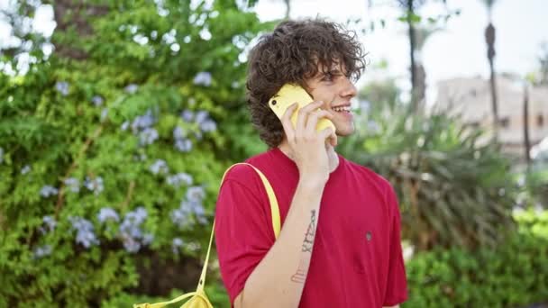 Homem Cabelos Encaracolados Sorridente Uma Camisa Vermelha Usando Telefone Amarelo — Vídeo de Stock