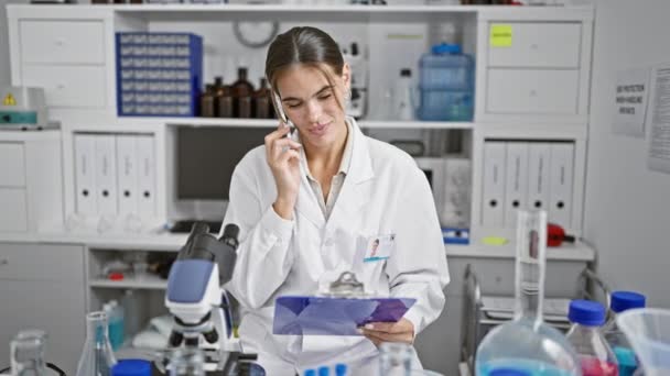 Stunning Young Hispanic Woman Scientist Reading Report Talking Smartphone Lab — Stock Video