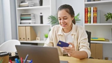 Muzaffer genç İspanyol kadın ofiste mali başarıyı kutluyor, güzel iş adamı internette çalışırken seviniyor, dizüstü bilgisayar açık, kredi kartı elinde.!