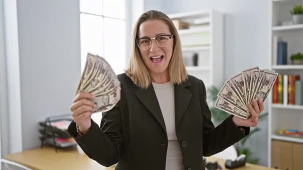 魅力的な若いブロンドのビジネス女性 オフィスで幸せとドル紙幣にキス — ストック動画
