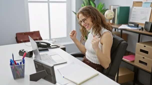 快乐的年轻获胜者 兴奋而美丽的女人在办公室里工作 跳着跳着 尖叫着为她的成功事业赢得了胜利 带着自信的微笑 工作中的快乐与胜利 — 图库视频影像