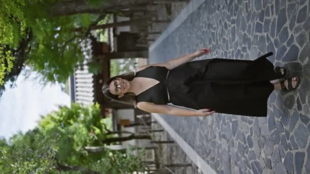 陽気で自信に満ちた美しいヒスパニック女性は 背の高いメガネで飾られ 散歩を楽しんで 京都の禅閣寺庭園でカメラのために輝きを放つ — ストック動画