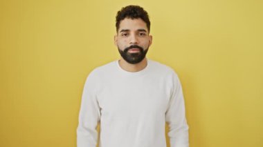 Neşeli genç bir adam seni ve kamerayı pozitif, gülümseyen bir yüzle işaret ediyor..