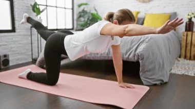 Sporcunun yolculuğu, genç, güzel sarışın kadın sağlıklı yaşam tarzını kucaklıyor, evdeki huzurlu yatak odası atmosferinde yoğun karın eğitimi egzersizine odaklanıyor.