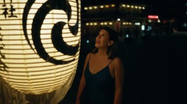 Tokyo 'daki Japon tapınağındaki Asya fenerine bakan genç ve güzel İspanyol kadın.