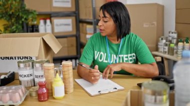 İspanyol kadın bir bağış merkezinde gönüllü olarak çalışıyor, bir depoda yemek organize ediyor..