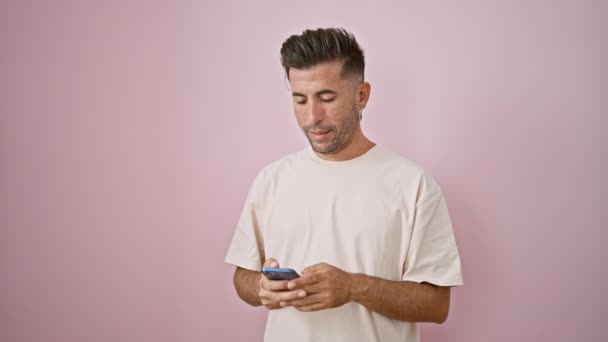 年轻自信的他的惊慌失措的男人喜欢活泼的视频通话 在明亮的粉色墙壁背景下 通过智能手机面带微笑 — 图库视频影像