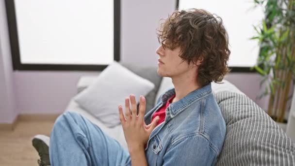Jovem Sereno Meditando Dentro Casa Sofá Mostrando Relaxamento Atenção Plena — Vídeo de Stock