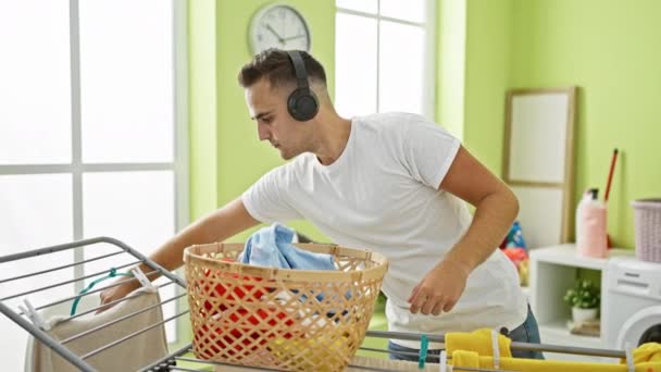Νεαρός Ισπανός Που Ακούει Μουσική Ακουστικά Ενώ Πλένει Ρούχα Του — Αρχείο Βίντεο