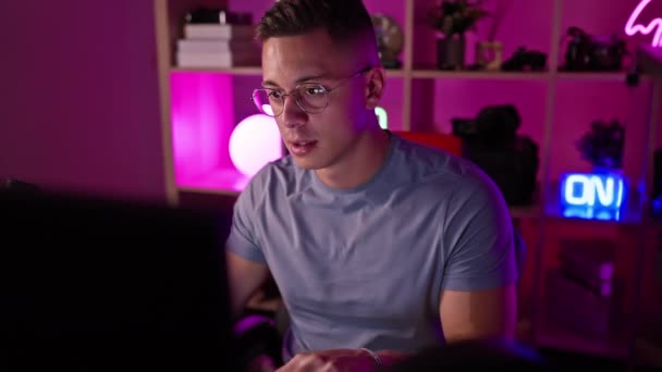 Soustředěný Mladý Muž Brýlích Herně Osvětlené Neonem Pracuje Noci Soustředěně — Stock video