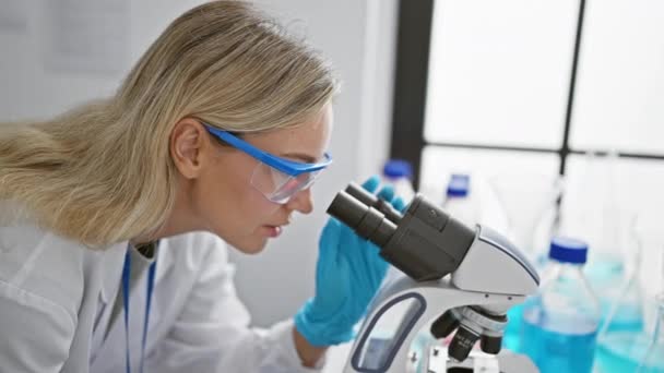 Focused Blonde Woman Scientist Using Microscope Modern Laboratory Setting Representing — Stock Video