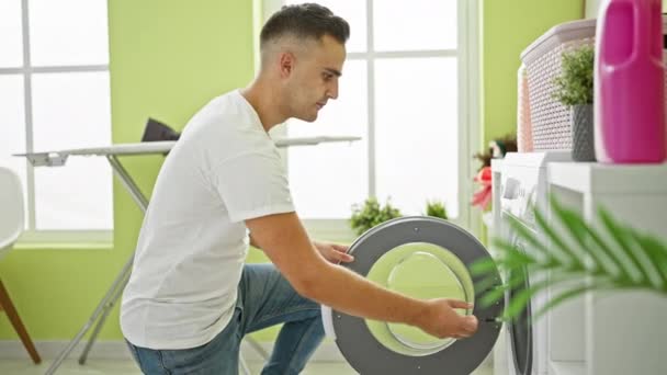 明るい緑の部屋で洗濯をするヒスパニック男性 洗濯機 家庭用品 インテリアの装飾 — ストック動画
