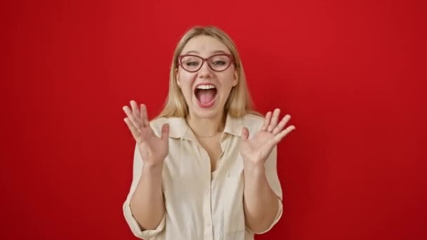 Gözlüklü Genç Sarışın Kadın Izole Edilmiş Kırmızı Arka Planda Duruyor — Stok video