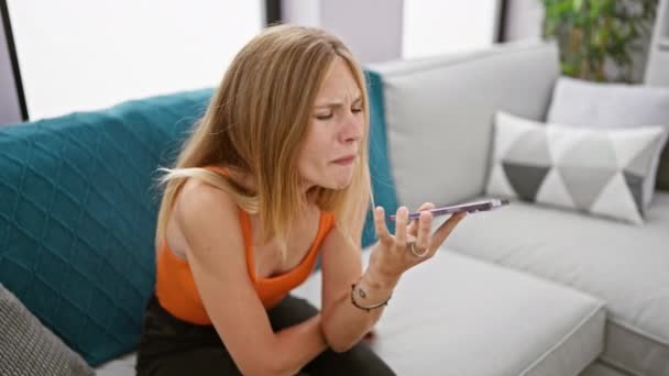 Attraktive Blonde Frau Frustriert Mit Smartphone Hause — Stockvideo