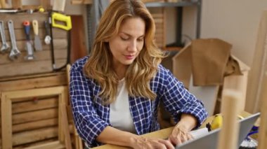 Marangozluk sessizliğinin ortasında sessiz sedasız oturan genç ve güzel Latin bir kadın. Masasında oturuyor, parmakları dudaklarında. Ahşap atölyedeki gizli jest..