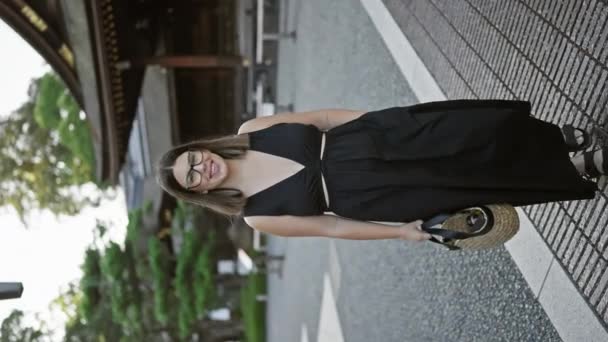 ヒスパニック系の女性を魅了し メガネでビームの笑顔を浮かべ 京都の象徴的な稲荷大社でカメラに向かって気軽にポーズをとり歩いた — ストック動画