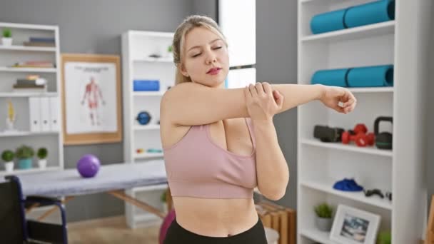 Een Jonge Blonde Vrouw Strekt Zich Uit Een Heldere Fysiotherapie — Stockvideo