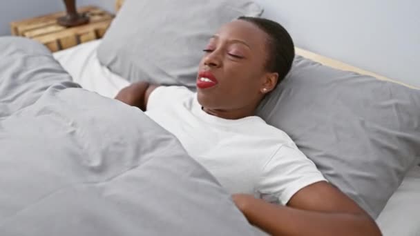 美丽的非洲裔美国女人躺在床上 她的脸上挂着愤怒的画像 她大声喊着 双手捂着嘴 躺在舒适的卧室里 — 图库视频影像