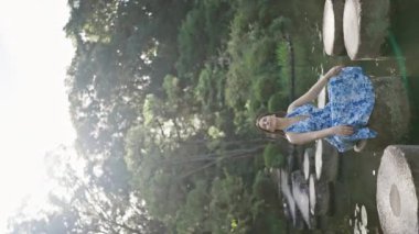 Güzel İspanyol kadın Heian Jingu Gölü 'nde taş yolda meditasyon yapıyor. Kyoto yazında doğanın zen' ini kucaklıyor.