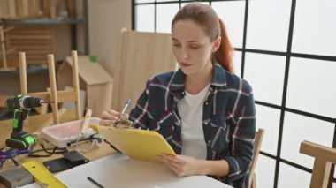 İyi ışıklandırılmış atölyede marangozluk projesi planlayan odaklı kadın